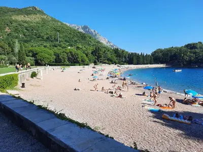 a group of people on a beach near the water at Luxury apartment near beach in Pržno