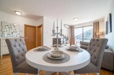 a dining room with a white table and chairs at Luxury apartment near beach in Pržno