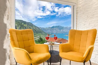 two chairs on a balcony with a view of the ocean at Apartment Petar 2 in Kotor