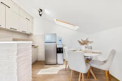a kitchen with a table with chairs and a refrigerator at Apartment Petar 2 in Kotor
