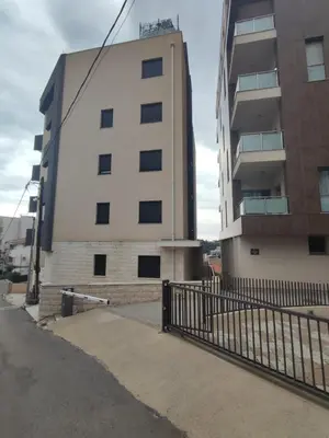 a tall building with a fence in front of it at Sea view apartment in Becici in Budva