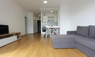 a living room with a couch and a kitchen at Sea view apartment in Becici in Budva