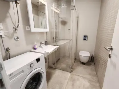 a bathroom with a washing machine and a shower at Sea view apartment in Becici in Budva