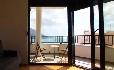 a room with a balcony with two chairs and a table at Sea view apartment in Becici in Budva