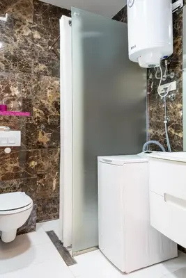a white bathroom with a toilet and a sink at Tre Canne Red Bull in Budva