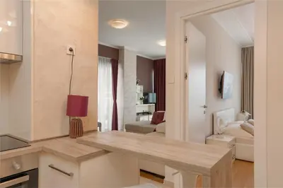 a kitchen and living room with a wooden table at Tre Canne Red Bull in Budva