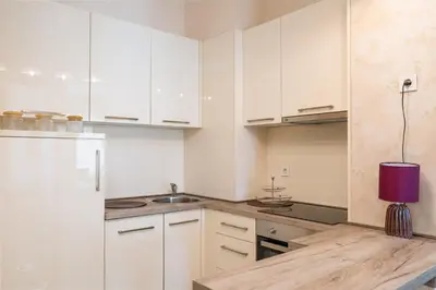 a kitchen with white cabinets and a purple lamp on a counter at Tre Canne Red Bull in Budva