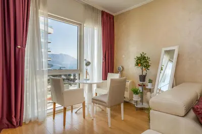 a living room with a couch and a table and a window at Tre Canne Red Bull in Budva