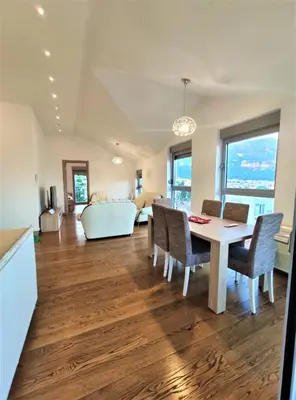 a dining room and living room with a table and chairs at Pavlina Apartments Budva in Budva