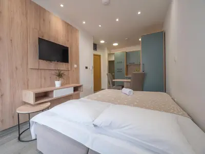 a bedroom with a bed and a tv on a wall at Marea Apartments Budva in Budva