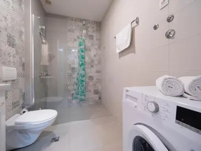 a bathroom with a toilet and a washing machine at Marea Apartments Budva in Budva