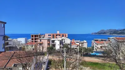 a city with buildings and the ocean in the background at Adriatique Apartments in Dobra Voda
