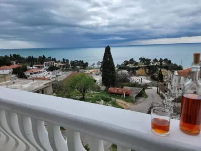 a wine glass sitting on a balcony with a view of the ocean at Apartments Adriatik in Ulcinj