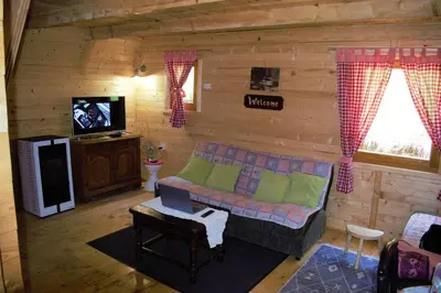 a living room with a couch in a log cabin at Breeze Home Cottage in Cetinje