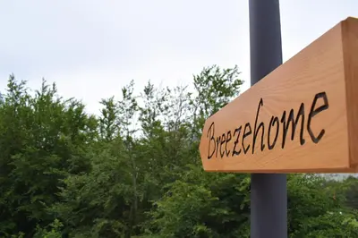 a sign for a restaurant with trees in the background at Breeze Home Cottage in Cetinje