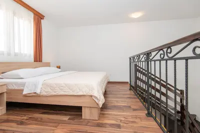 a bedroom with a bed and a wooden floor at Ethno Village St George in Cetinje
