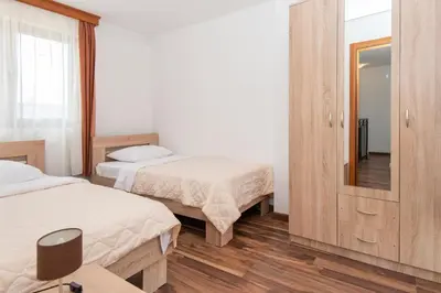 a hotel room with two beds and a mirror at Ethno Village St George in Cetinje