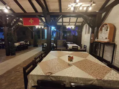 a table in a restaurant with a flag on it at Ethno Village St George in Cetinje