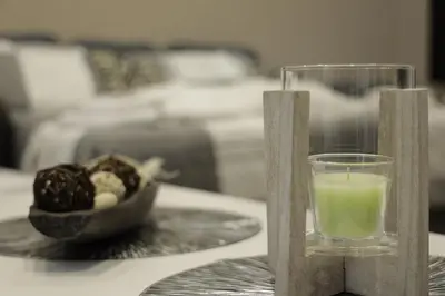 a candle and a glass on a table with a bowl of food at Apartment Alexandra in Budva