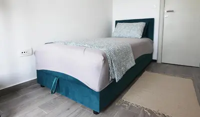 a bedroom with a bed with a blue and white comforter at Romantic sea view apartment in Petrovac in Petrovac na Moru