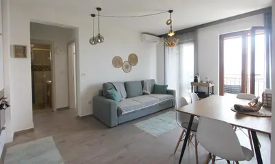 a living room with a couch and a table at Romantic sea view apartment in Petrovac in Petrovac na Moru
