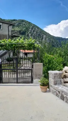 a black gate in front of a building with a mountain at Anastasija 2 in Kotor