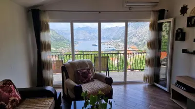 a living room with a chair and a balcony at Anastasija 2 in Kotor