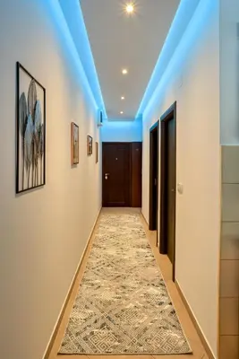 a hallway with blue lighting and a rug on the floor at Apartment With a View in Budva