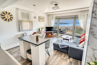 a living room with a couch and a table at Apartment With a View in Budva