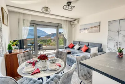 a living room with a table and chairs and a couch at Apartment With a View in Budva