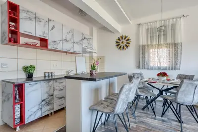 a kitchen with a table and chairs in a room at Apartment With a View in Budva