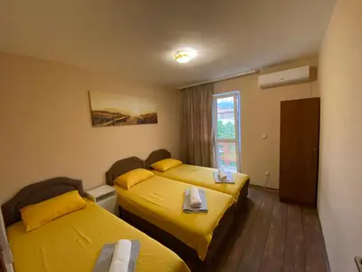 two beds in a hotel room with yellow sheets at Apartments and Rooms Grande Casa in Bar