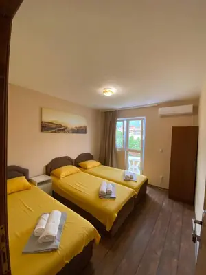 two beds in a hotel room with yellow sheets at Apartments and Rooms Grande Casa in Bar