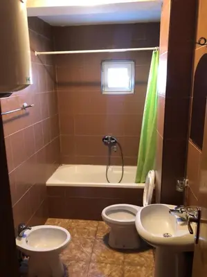 a bathroom with a toilet and a sink and a shower at Apartments and Rooms Grande Casa in Bar