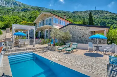 a home with a swimming pool and a house at Adriatic paradise in Budva