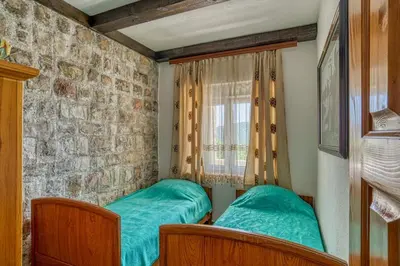 a bedroom with two beds and a brick wall at Adriatic paradise in Budva