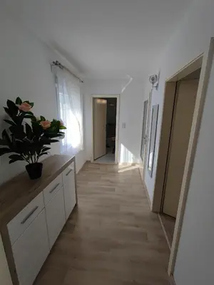 a hallway of a room with white walls and wooden floors at Apartment Barba View in Kotor