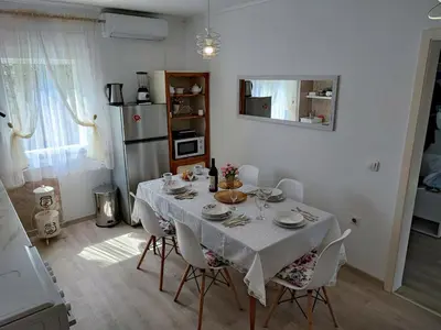a dining room with a white table and chairs at Apartment Barba View in Kotor