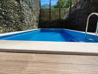 a small swimming pool with a wooden floor and a fence at Villa Vista Real in Kotor