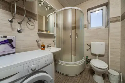 a bathroom with a shower and a toilet and a sink at Apart hotel St.Pijerre in Stari Bar