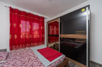 a bedroom with a bed and a red curtain at Apart hotel St.Pijerre in Stari Bar
