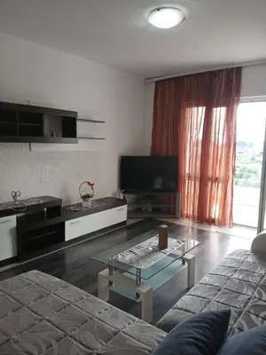 a living room with a couch and a glass coffee table at Apart hotel St.Pijerre in Stari Bar