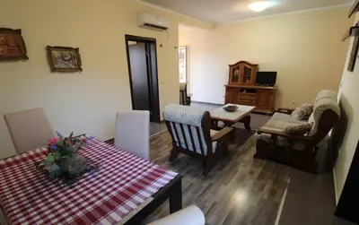 a living room with a table and chairs and a dining room at Apart hotel St.Pijerre in Stari Bar