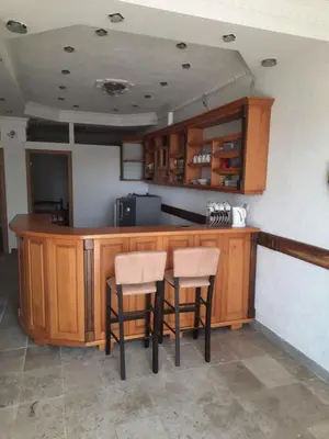 a kitchen with a wooden bar with two stools at Apartman LOKI in Ulcinj