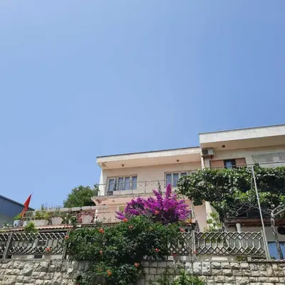 a building with purple flowers in front of it at Apartman LOKI in Ulcinj