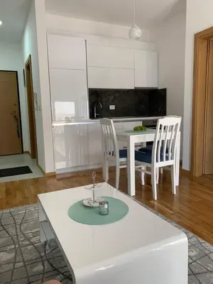 a white kitchen with a table and two chairs at Apartman A2 in Ulcinj