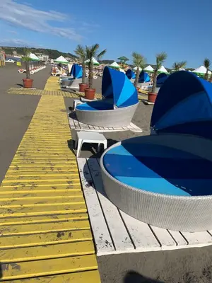a row of benches with umbrellas on a beach at Apartman A2 in Ulcinj