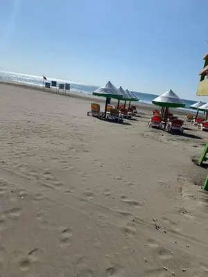 a beach with chairs and umbrellas and the ocean at Apartman A2 in Ulcinj