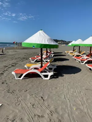 a row of lounge chairs and umbrellas on a beach at Apartman A2 in Ulcinj
