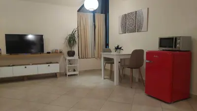 a living room with a red refrigerator and a table at Mila's studio in Kotor